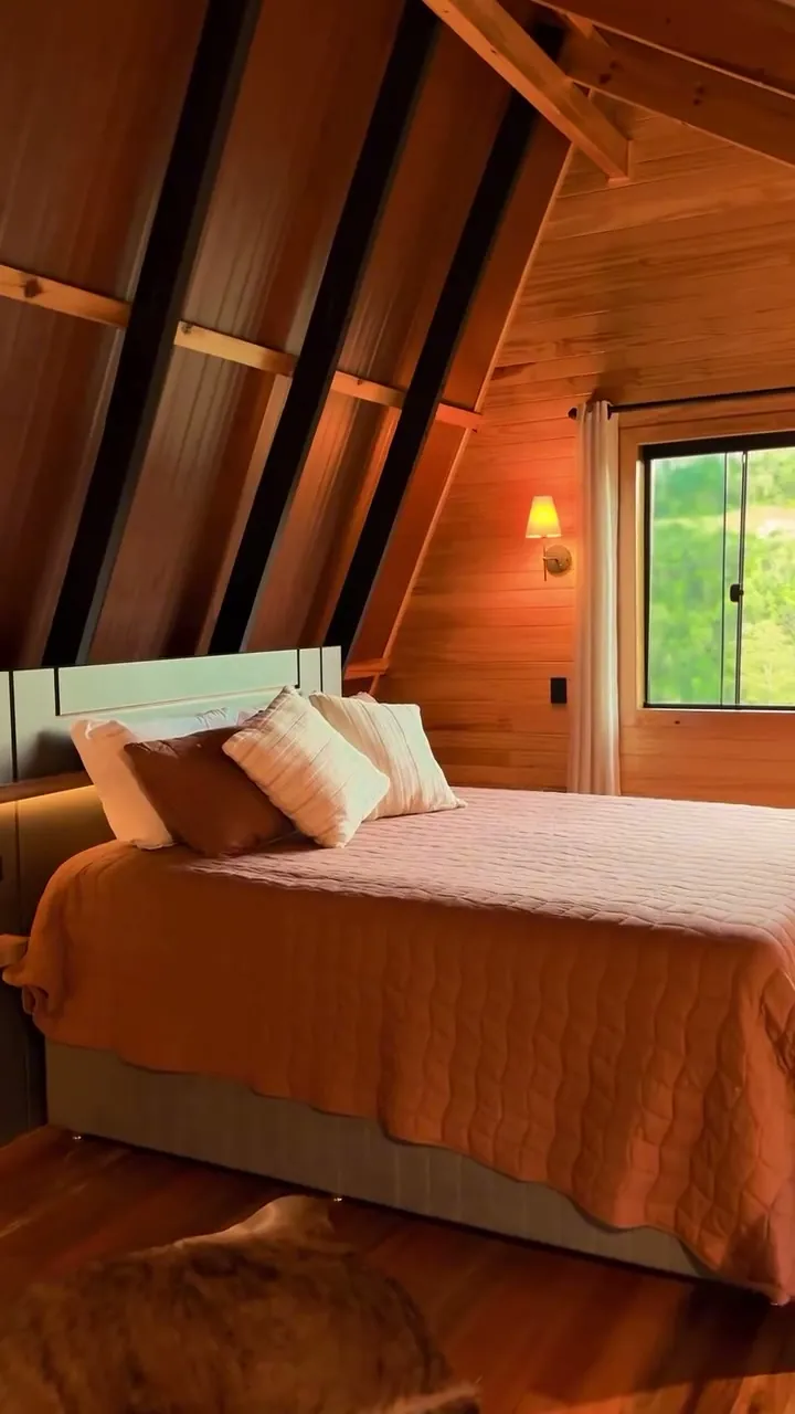 Quarto da Cabana Omega em madeira, com cama de casal e janela para o verde